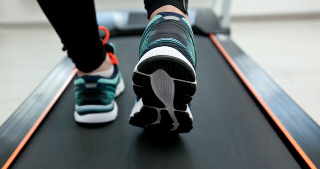 Ein Laufband - darauf sind die Füße einer trainierenden Person zu sehen - als Symbol für unsere Schreibtrainings